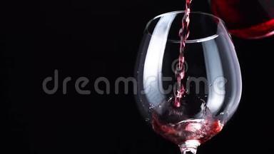 红葡萄酒或红酒被倒入黑色背景的玻璃酒杯中